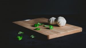 garlic bulb spinach leaves on cutting board